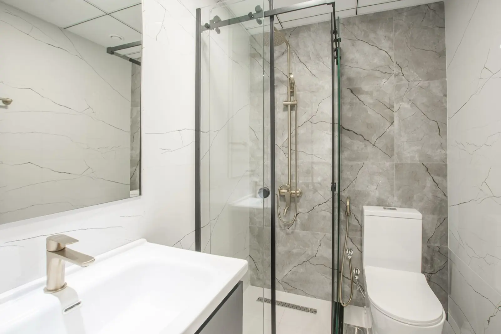 A finished frameless glass shower enclosure in a tiled bathroom.