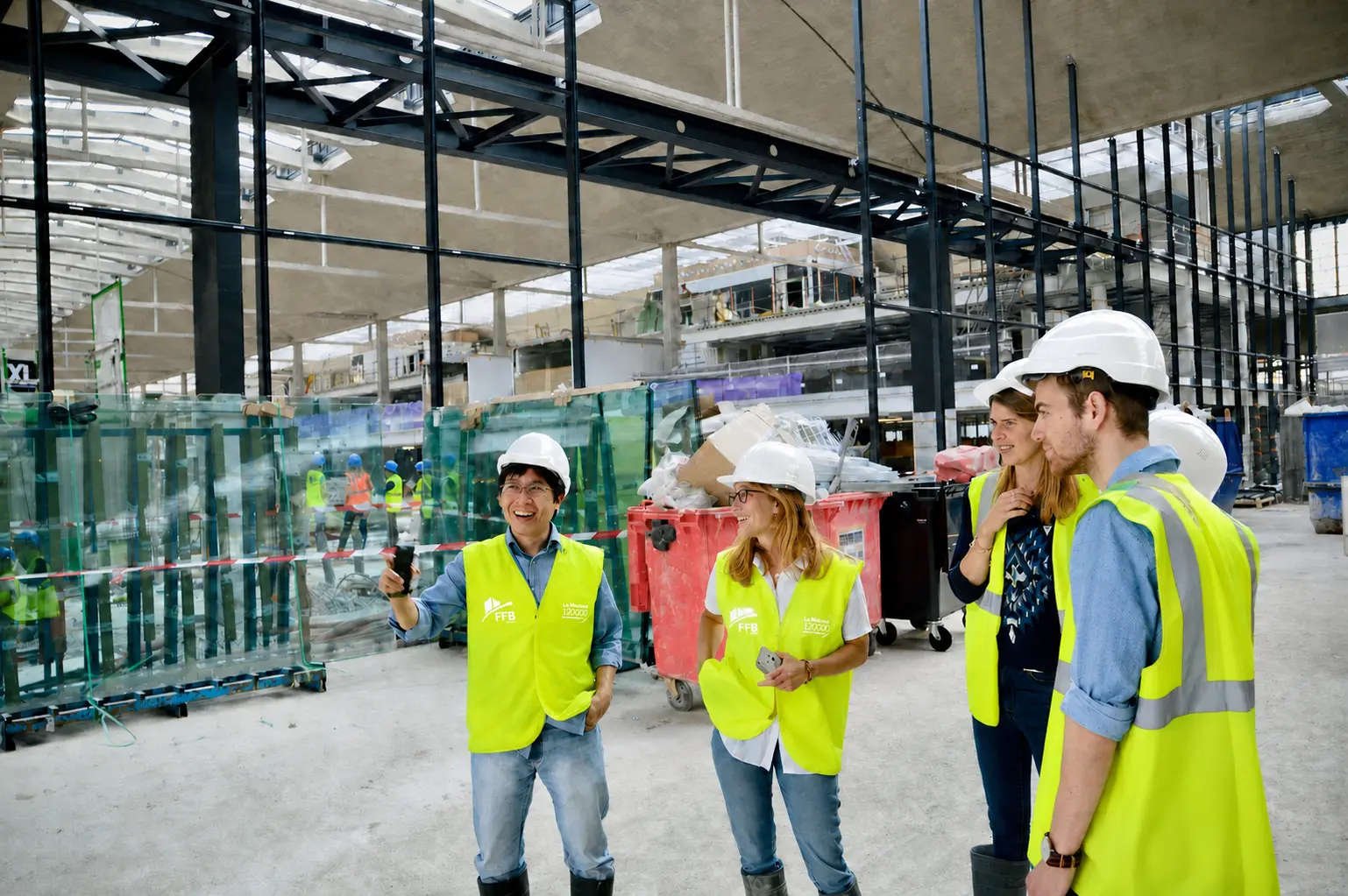 A construction team coordinating beside large glass panels